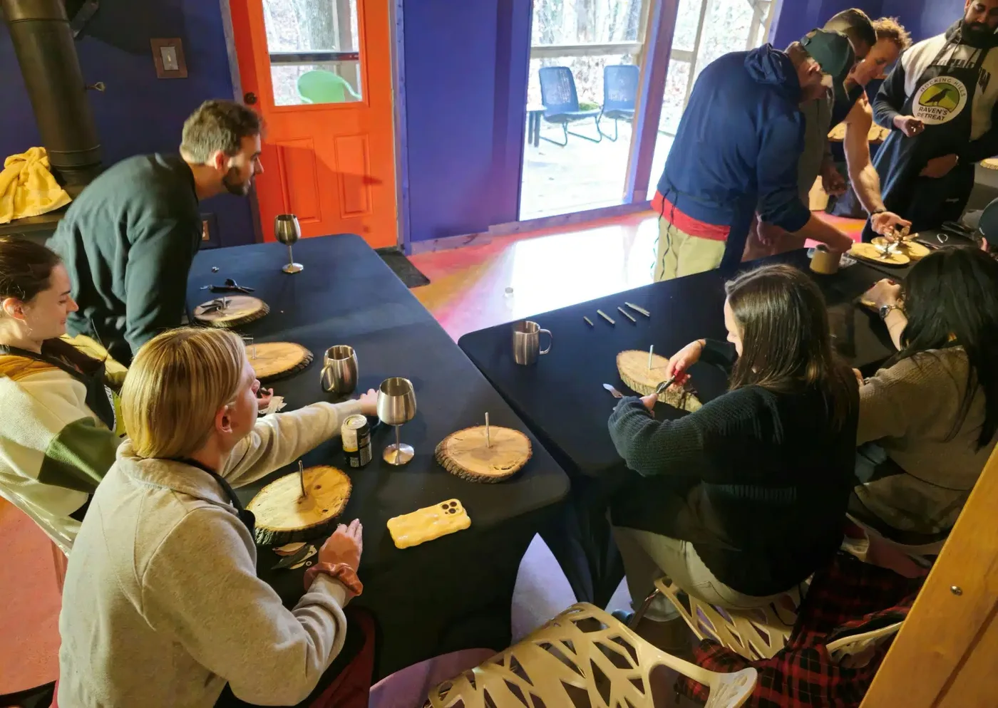 Guests working on hands-on art projects at long tables inside the Art Lodge