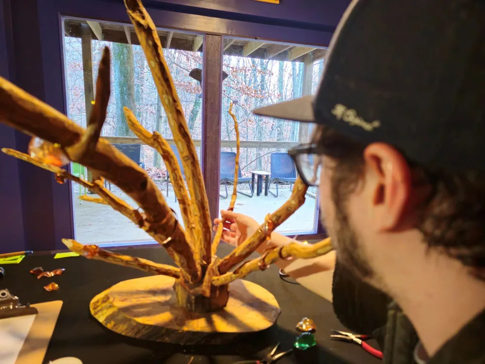 A guest shaping a nature-inspired wood sculpture during the individual project session