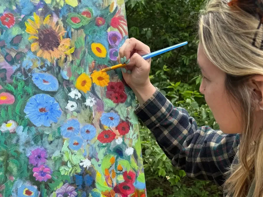 A guest painting during a group art workshop day retreat at Raven's Retreat