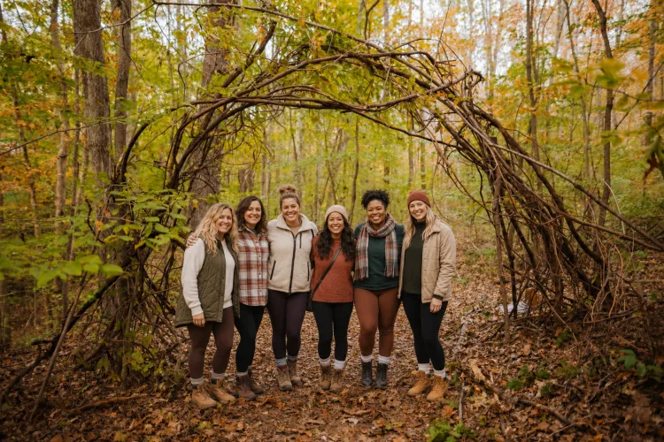 Forest bathing group under a branch arch on the wellness trail at Raven’s Retreat Hocking Hills