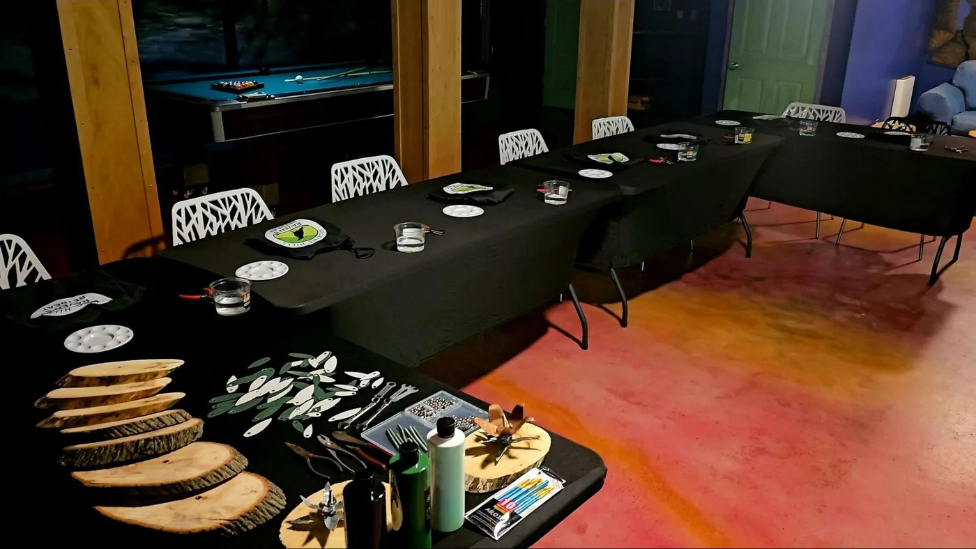 Workshop tables set with live-edge wood slices and sculpting materials in the Art Lodge before a team retreat