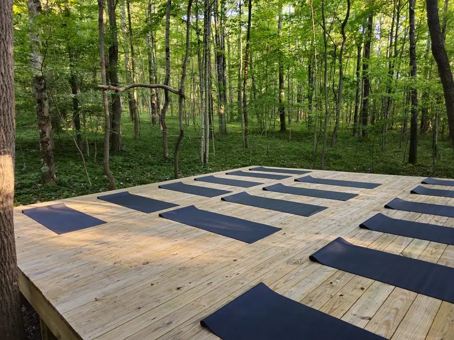 Women practicing yoga together on the elevated forest platform at Raven's Retreat Hocking Hills