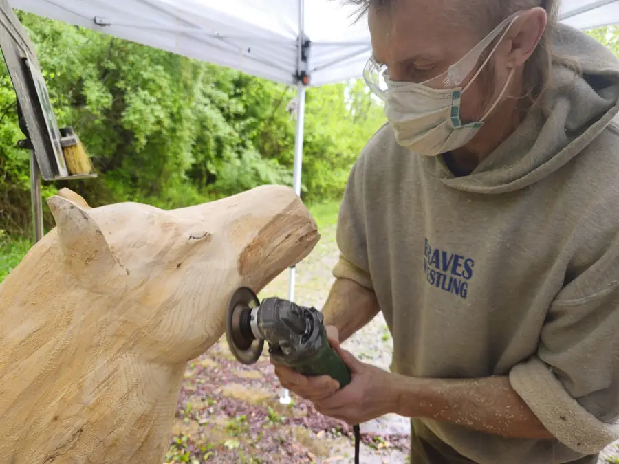 Dustin Weatherby carving a large wood sculpture during a live art performance