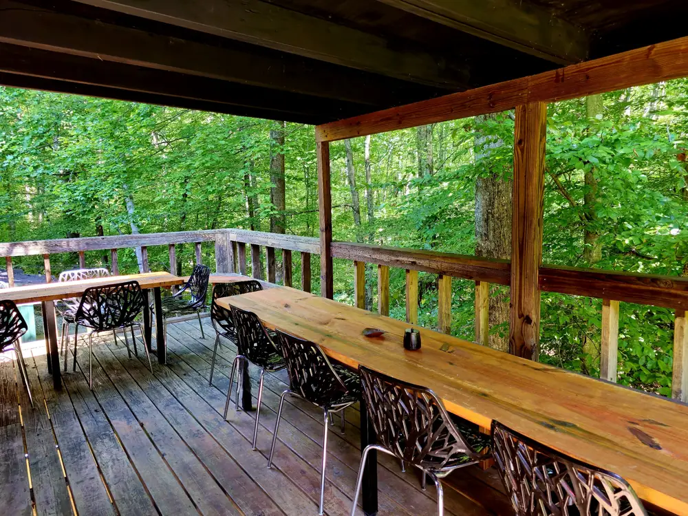 Outdoor balcony dining overlooking the forest at the Art Lodge