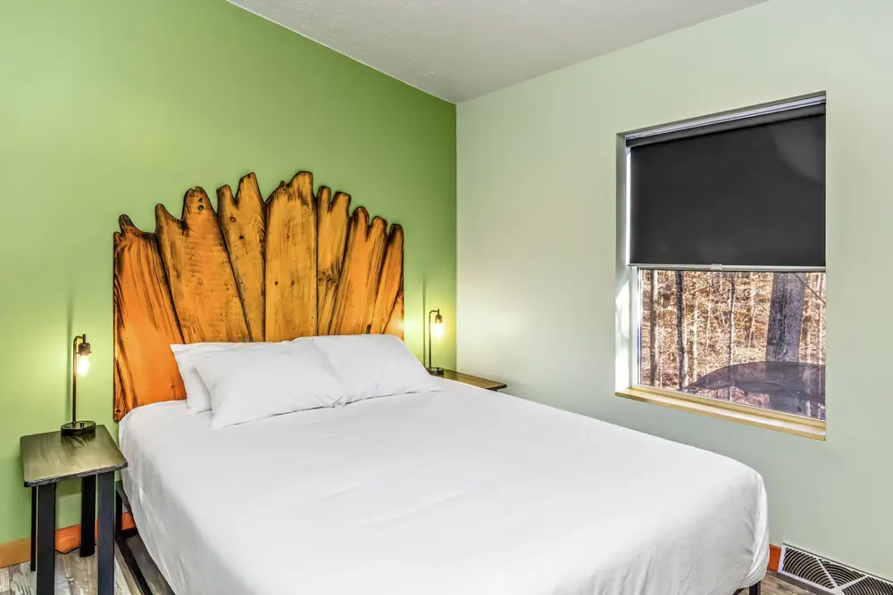 A bedroom in the Art Lodge with a hand-carved wooden headboard