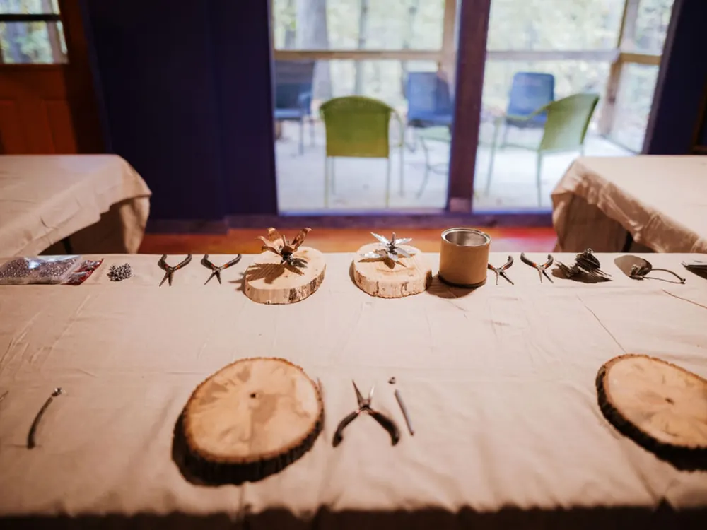 Workshop tables laid out with tools and wood rounds before a session in the Art Lodge