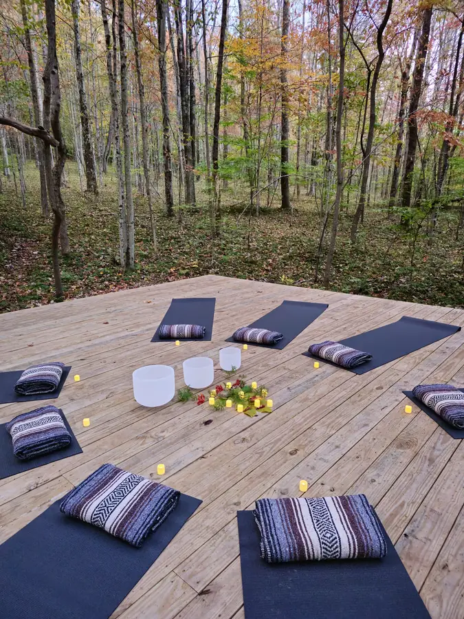 Crystal singing bowls and mats set out for a sound bath on the forest platform