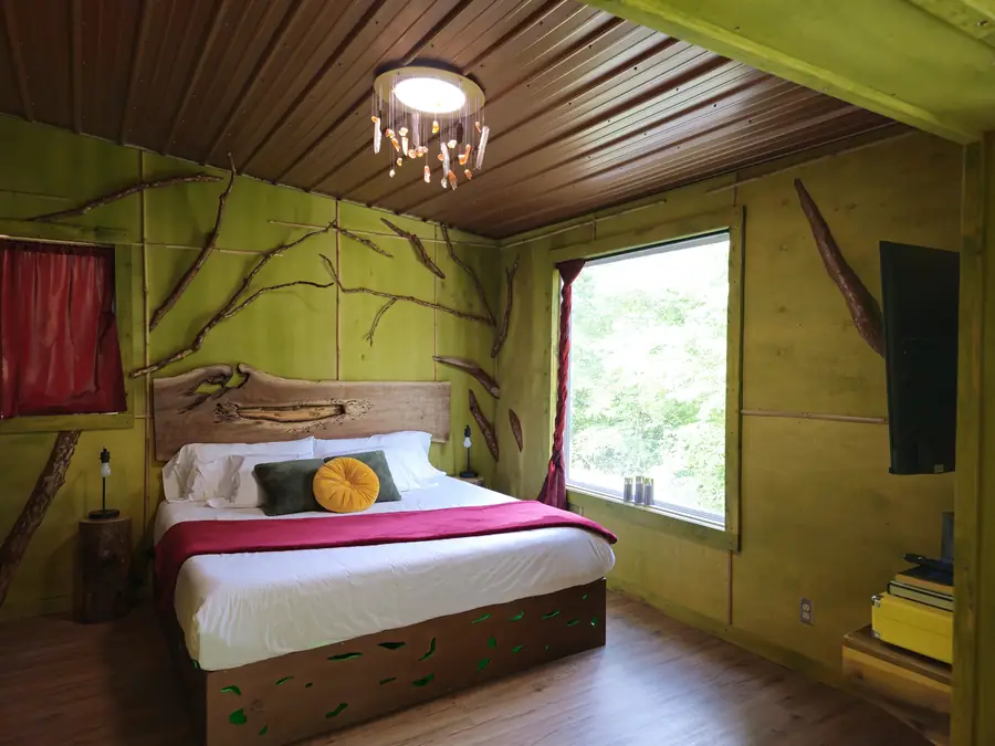 A bedroom in the Sculptor's Art Bungalow with a hand-carved headboard