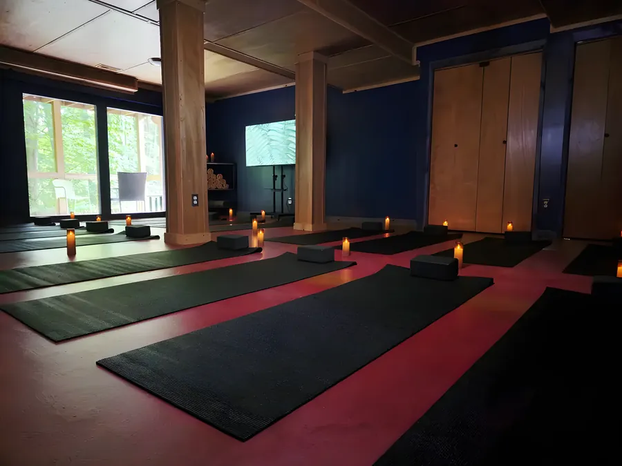 The candlelit yoga shala inside the Sculptor's Art Lodge, mats and candles laid out for a session at Raven's Retreat Hocking Hills