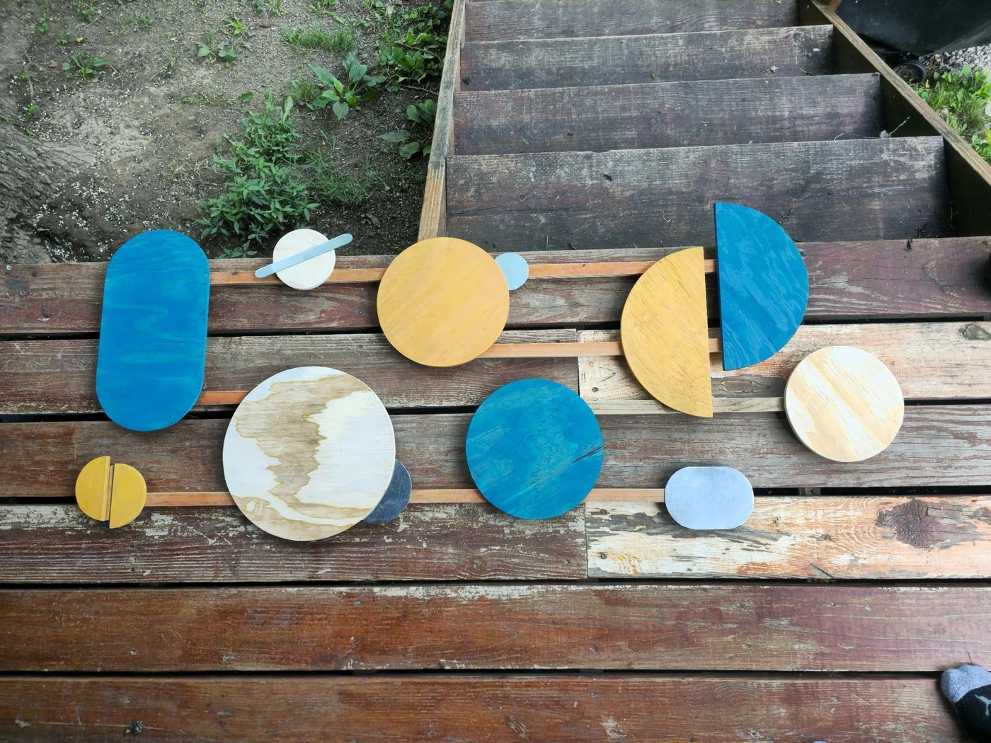 Finished painted wood planet sculpture pieces made during a sculpting workshop at Raven’s Retreat Hocking Hills