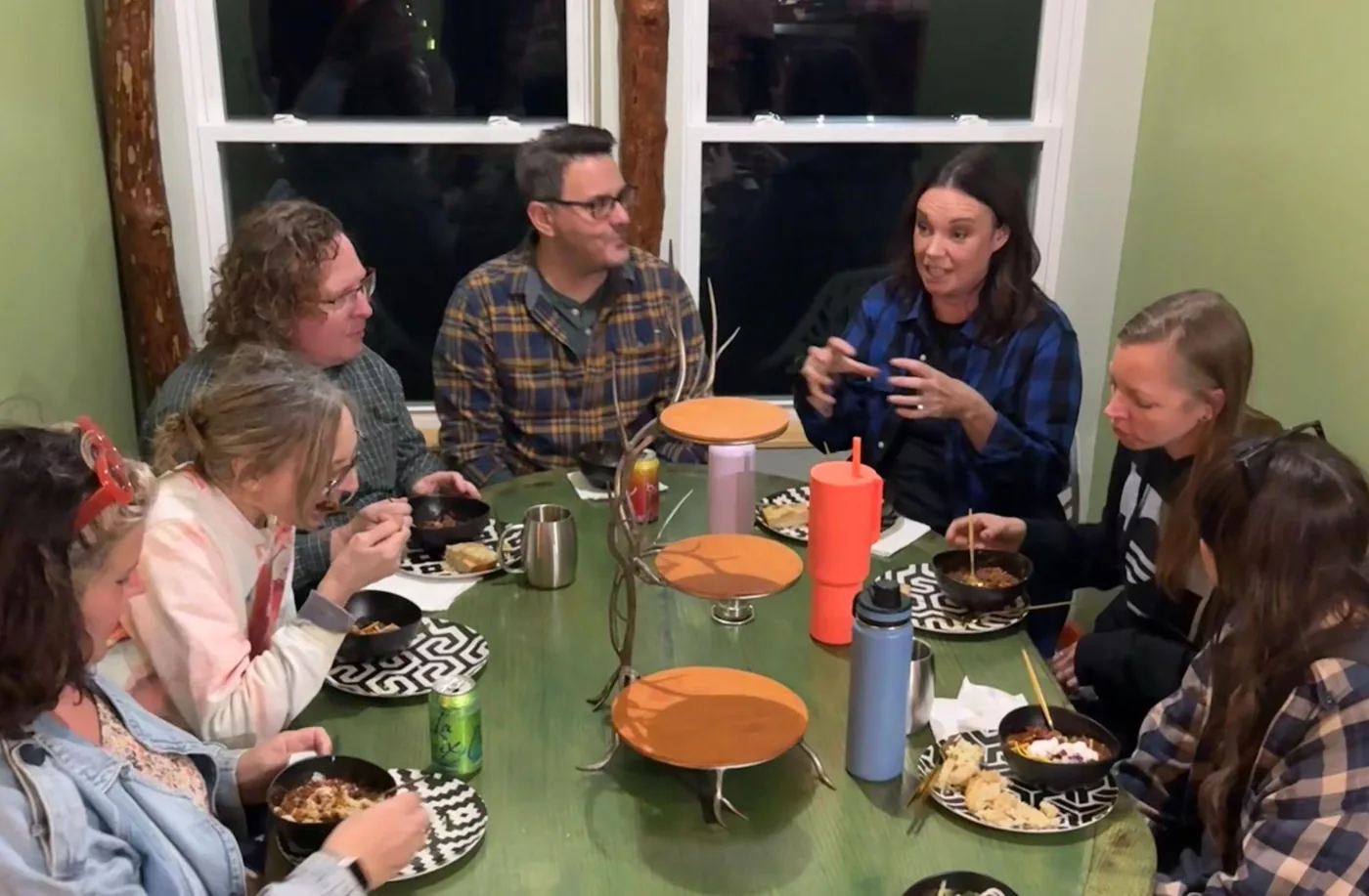 Retreat guests sharing a meal and conversation around the table at Raven’s Retreat Hocking Hills