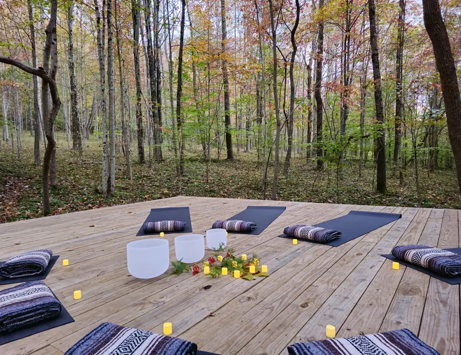 Sound bath set up with crystal singing bowls on the elevated forest platform at Raven’s Retreat