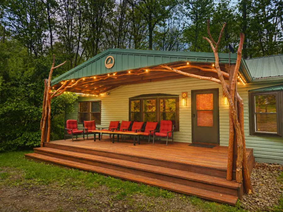 The lantern-lit front porch of the Sculptor's Art Lodge with its hand-carved branch posts