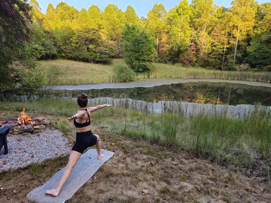 Guest practicing yoga alone beside the pond during a solo retreat
