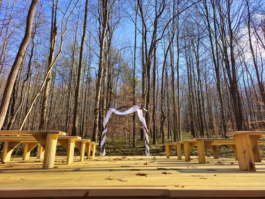 Ceremony arch and benches set up for a forest micro-wedding at Raven's Retreat