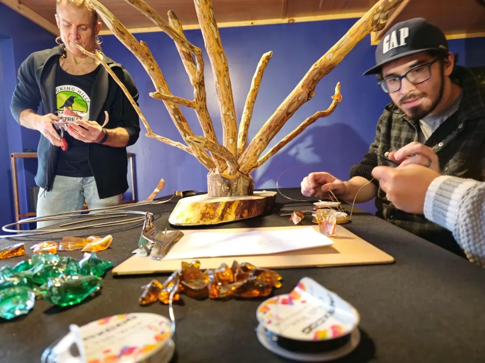 Guests building a driftwood and glass sculpture together during a celebration workshop