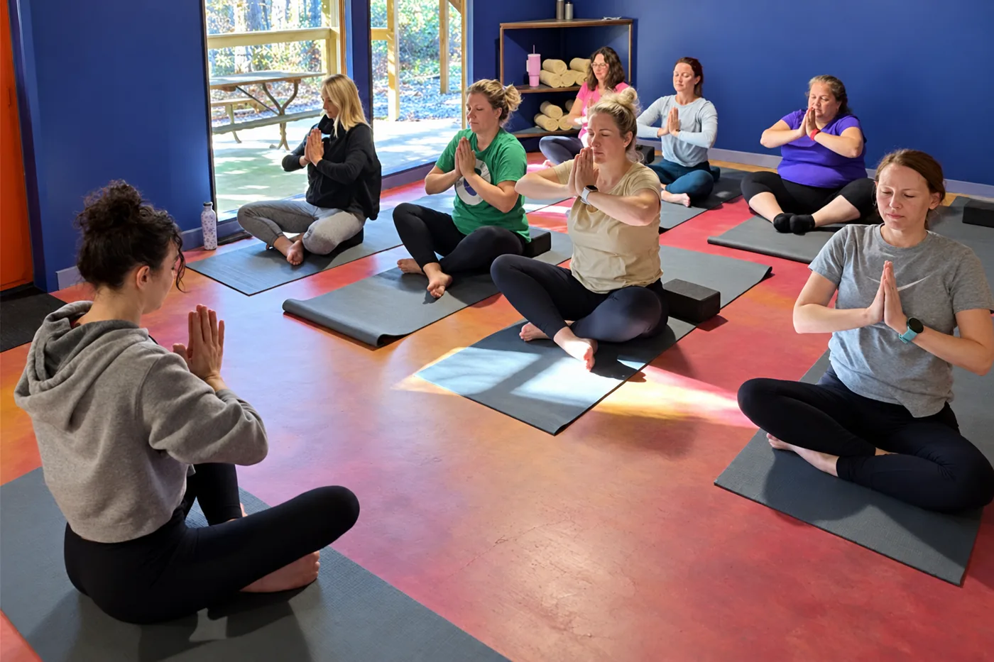 Group meditating on mats in the indoor yoga shala at Raven’s Retreat Hocking Hills